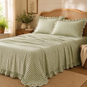 May include: A sage green and white gingham patterned bedspread set featuring two matching pillow shams with ruffled edges. The bedding set includes a ruffled skirt along the bottom edge of the coverlet, providing a consistent checkered design throughout.