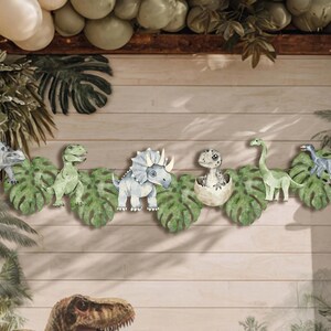 Staged party scene featuring Joy Ladder Dinosaurs banner hung on wall