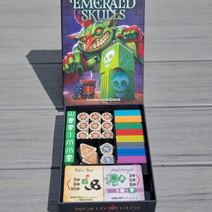 Puede incluir: Insert de juego impreso en 3D para el juego de mesa Emerald Skulls. El insert tiene compartimentos para dados, fichas y cartas. El insert es negro con acentos verdes y blancos. El insert está diseñado para caber en la caja del juego.