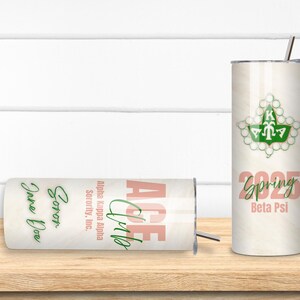May include: Two stainless steel tumblers with lids and straws. One is upright, the other is horizontal. Both have a light wood grain pattern. The upright tumbler features a green and white sorority crest, the word "Spring", and "2025". The horizontal tumbler has the words "ACE Club" and "Jane Doe".