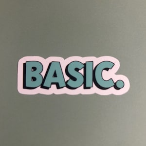 May include: A sticker with the word "BASIC" in teal letters with a black outline and a white border. The sticker is on a gray surface.