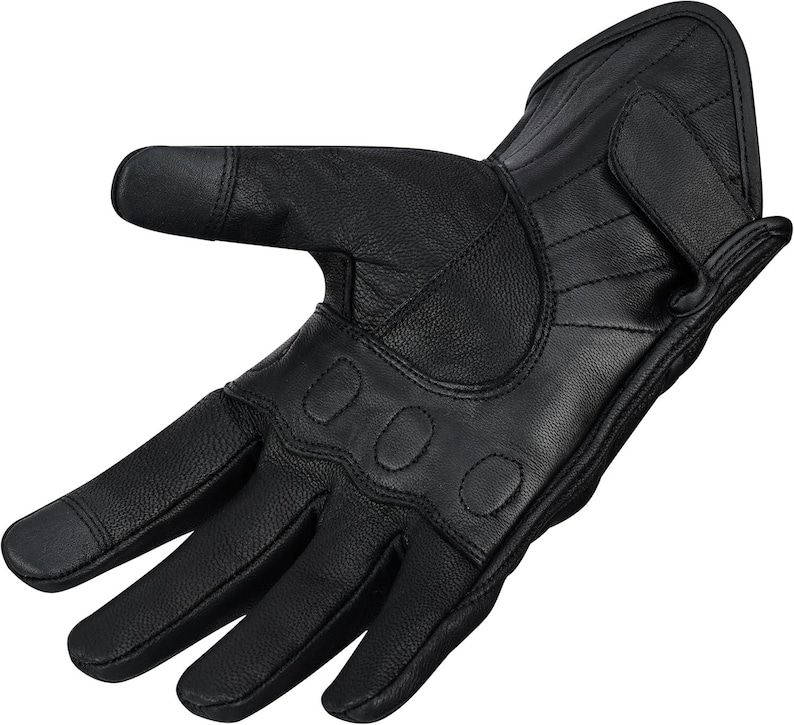 May include: Black leather motorcycle glove with reinforced knuckles and a wrist strap. The glove features a textured surface and is designed for protection and grip. The fingers have a touch-sensitive tip for use with smartphones.