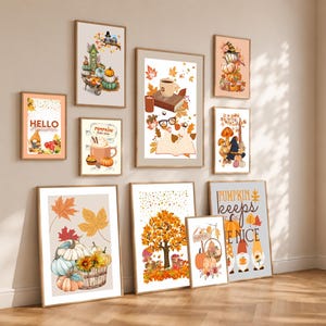 May include: A collection of ten framed wall art prints featuring autumn themes, including pumpkins, fall foliage, gnomes, coffee mugs, and books. The prints display warm orange, yellow, and brown colour palettes with various seasonal illustrations.