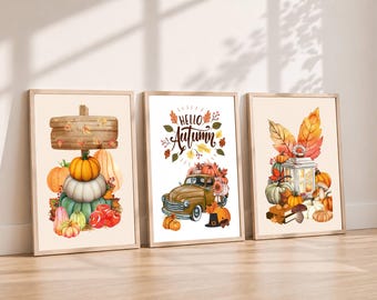 May include: Three framed wall art prints featuring autumn themes. The first shows a wooden sign above a stack of pumpkins and gourds. The second displays a vintage truck filled with pumpkins and the text Hello Autumn. The third depicts a lantern.