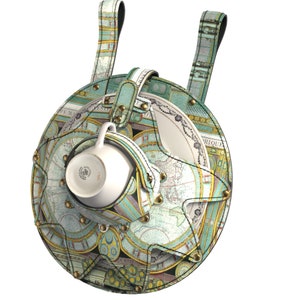 Può includere: Una tazzina da tè e un piattino in ceramica bianca con un bordo dorato sono attaccati a un porta tazze rotondo in pelle. Il porta tazze è decorato con un design di mappa del mondo vintage in tonalità di verde, blu e oro. Il porta tazze ha due cinturini in pelle per appenderlo.