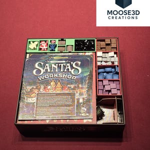 Op de afbeelding: Een bordspel organizer voor "Santa's Workshop" met diverse compartimenten. De speldoos bevat spelstukken, kaarten en een spelbord. De organizer is ontworpen om de spelcomponenten georganiseerd en toegankelijk te houden.