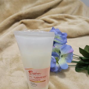 May include: A white plastic tube of VC Turmeric Cleanser with a pink and orange label. The label says "Coshen Pure Skincare" and "VC Turmeric Cleanser". The label also says "Turmeric Brightening" and "Vitamin C Serum Boost".