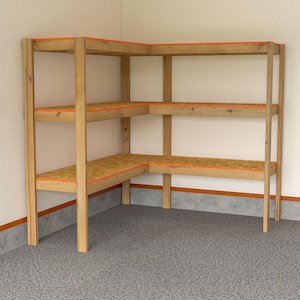 May include: A wooden corner shelving unit with three shelves. The shelves are made of light-colored wood with orange trim. The unit is in a corner of a room with light-colored walls and a speckled gray floor.