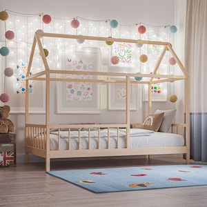 以下が含まれることがあります： 子供部屋にある、すのこベースの木製ハウスベッド。ベッドはカラフルな形をした青いラグの上にあります。部屋は額入りのアート、フェアリーライト、装飾的なポンポンで飾られています。ベッドの長さは約190cmです。