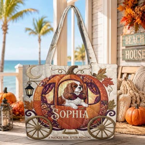 May include: A quilted tote bag featuring a brown and white Cavalier King Charles Spaniel inside a pumpkin carriage illustration. The text reads Sophia and A magical ride after midnight. The design includes autumn leaves and a lantern.