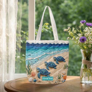 May include: A quilted tote bag featuring a beach scene with three blue sea turtles on a sandy shore. The design includes ocean waves, seashells, and the text "Custom Name". The bag has white handles and a blue and white wave pattern at the top.
