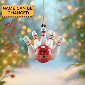 May include: A bowling-themed Christmas ornament featuring a red bowling ball and white bowling pins with red stripes. The ornament has a gold string for hanging and the text "NAME CAN BE CHANGED" on a yellow banner.