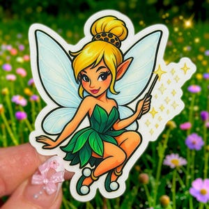 May include: A sticker of a cartoon fairy with blonde hair, a green dress, and blue wings. The fairy holds a wand with star-shaped sparkles. The sticker is on a white background with a green and floral background.