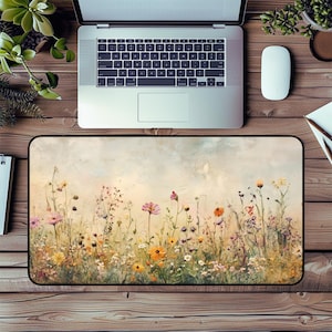 May include: A watercolor-style mouse pad featuring a field of wildflowers in shades of pink, purple, yellow, and white. The background is a soft, faded blue.