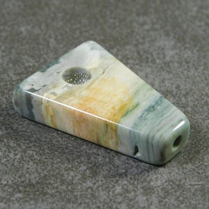 May include: A triangular shaped pipe made of green, white, and orange agate with a metal screen.