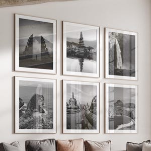 May include: A living room featuring six framed black and white landscape photographs. The images depict temples, waterfalls, and natural scenery. A large sectional sofa with multiple throw pillows and a set of round coffee tables complete the scene.