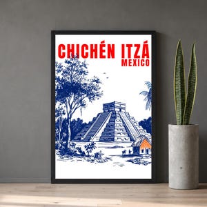 May include: Framed art print featuring a blue and white illustration of Chichén Itzá, Mexico. The text "CHICHÉN ITZÁ MEXICO" is in red at the top. The artwork depicts the pyramid, trees, and a small building with an orange roof.
