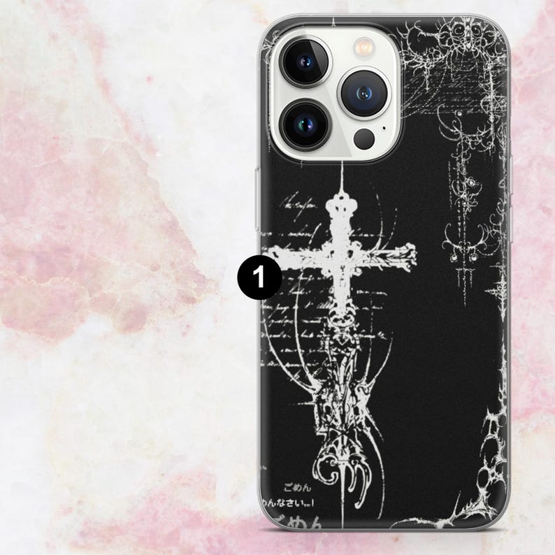 May include: Black phone case featuring a white cross design with ornate details. The case has a glossy finish and includes Japanese text at the bottom. The design is set against a black background.