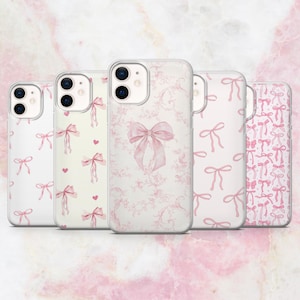 Könnte beinhalten: Vier transparente Handyhüllen mit rosa Schleifendesigns. Die Hüllen haben einen weißen Hintergrund mit rosa Schleifen und Blumenmustern.