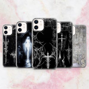 May include: A collection of five phone cases with gothic-inspired designs. Each case features a black background with white or gray artwork, including crosses, swords, and abstract patterns. The cases are made of clear plastic.