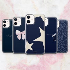 May include: Five different phone cases with various designs. The cases are all clear and show a navy blue background with different patterns. One case has a white star and a pink bow, another has a white star and a pink bow, another has a white star and a pink bow, another has a white star and a pink bow, and another has a leopard print.