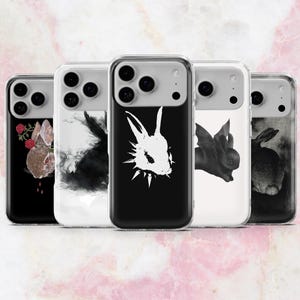Puede incluir: Una colección de cinco fundas para teléfono con diseños únicos con temática de conejos. Las fundas presentan varios estilos artísticos, incluyendo un conejo marrón con rosas, una silueta negra, un conejo blanco con un collar puntiagudo, un conejo negro con alas y un conejo en escala de grises.