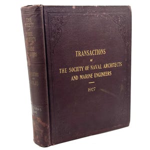 Puede incluir: Un libro de tapa dura marrón oscuro titulado Transactions of The Society of Naval Architects and Marine Engineers 1927. La portada presenta letras doradas en relieve y bordes decorativos. El lomo muestra el mismo título y el volumen 35.