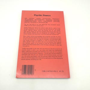 K&ouml;nnte beinhalten: Ein Vintage-Taschenbuch mit dem Titel "Psychic Powers" mit rotem Einband. Das Cover zeigt eine Liste psychischer F&auml;higkeiten und Text. Das Buch hat einen Barcode und die ISBN 0-87542-191-1.