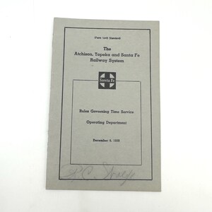 Può includere: Un documento d'epoca del sistema ferroviario Atchison, Topeka e Santa Fe. La carta grigia presenta un testo nero che recita "Rules Governing Time Service" e "Operating Department". Il documento è datato 6 dicembre 1959 e include una firma.