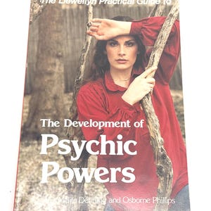 K&ouml;nnte beinhalten: Buchcover mit dem Titel "The Development of Psychic Powers" in wei&szlig;er Schrift. Das Cover zeigt eine Frau in einem roten Hemd, die sich an einen Ast lehnt. Das Buch geh&ouml;rt zur Reihe "The Llewellyn Practical Guide to".