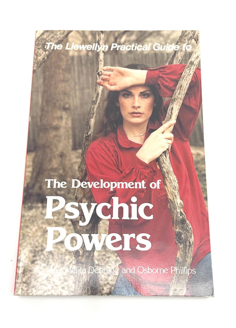 K&ouml;nnte beinhalten: Buchcover mit dem Titel "The Development of Psychic Powers" in wei&szlig;er Schrift. Das Cover zeigt eine Frau in einem roten Hemd, die sich an einen Ast lehnt. Das Buch geh&ouml;rt zur Reihe "The Llewellyn Practical Guide to".