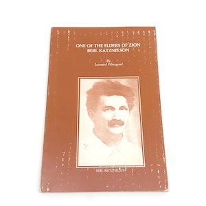 May include: A vintage book titled "One of the Elders of Zion Berl Katznelson" by Leonard Winograd. The cover is brown with text and a portrait of a man with a moustache. The book shows signs of wear.