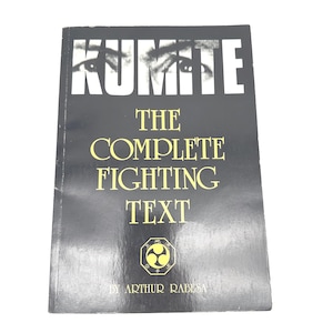 May include: A black book titled "Kumite" with the subtitle "The Complete Fighting Text" and the author's name, Arthur Rabesa. The cover features a close-up of eyes above the title in white letters and gold lettering for the subtitle.