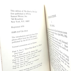May include: Open book with text from "The Book of the Law" published in 1976 by Samuel Weiser, Inc. The book's introduction and text are photo-offset from the 1938 edition. Textual corrections are listed on the left page.