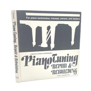 May include: A book titled "Piano Tuning, Repair & Rebuilding" by Floyd A. Stevens. The cover is white and gray with text that reads "For piano technicians, trainees, owners, and dealers". The book is a complete course in professional piano tuning.