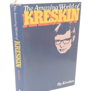 May include: A blue hardcover book titled "The Amazing World of KRESKIN". The title is in yellow and orange lettering. The cover features a portrait of a man wearing glasses. The author's name, Kreskin, is also on the cover.