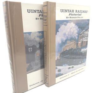 May include: Two hardcover books titled "UINTAH RAILWAY Pictorial" by Rodger Polley. Volume I and II are visible. The covers feature images of trains and landscapes, with text in black and white. The spines are a light tan color.