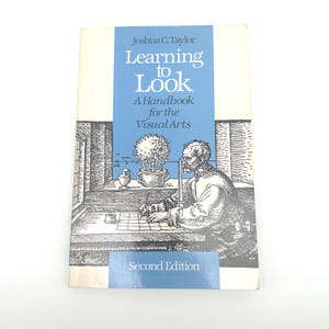 May include: A hardcover book titled "Learning to Look: A Handbook for the Visual Arts" by Joshua C. Taylor. The cover features a blue band with white text and a black and white illustration of a person drawing. The words "Second Edition" are also visible.