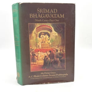 May include: A hardcover book titled "Śrīmad Bhāgavatam, Ninth Canto-Part One." The book has a brown cover with gold lettering and a detailed illustration of a religious scene. The spine is green with white text.
