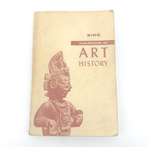 May include: A vintage "handbook of ART HISTORY" book with a faded cover. The cover features a reddish-brown illustration of a Mayan statue. The book's title is printed in a bold, sans-serif font, with the author's name, "BIRÓ", at the top.