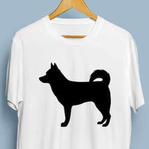 May include: White t-shirt with a black silhouette of a dog on the front.