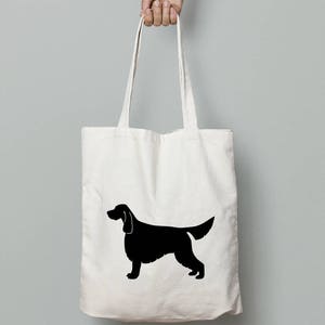 May include: A white canvas tote bag with a black silhouette of an Irish Setter dog.