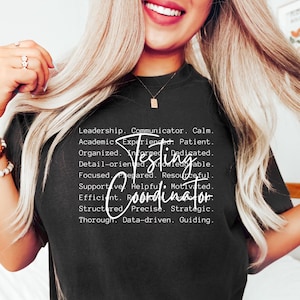 May include: Black t-shirt with the words "Testing Coordinator" in white script. The shirt also lists several positive attributes such as "Leadership," "Communicator," and "Organized."