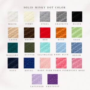 Op de afbeelding: Een kleurenkaart met verschillende tinten minky dot stof. De kaart bevat kleuren zoals wit, ivoor, staal, grafiet, zwart, latte, bruin, rood, roest, salie, mallard, jager, zeewater, babyblauw, denim, marine, koninklijk, babyroze, parijsroze, stoffig roze, lavendel en amethist.