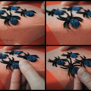 May include: Black spider decorations with blue glitter bodies are arranged on a light orange surface. The image shows the process of placing the spiders. The website address cupcakesbychristy.com is visible in the image.