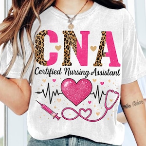May include: White t-shirt with the text "CNA Certified Nursing Assistant" in pink and leopard print. The shirt features a pink heart, a stethoscope, and a syringe design.