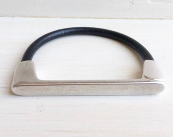 May include: A silver metal bracelet with a black leather band.