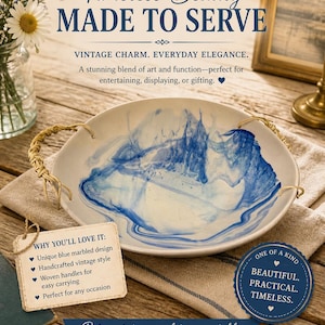 Op de afbeelding: Een witte serveerschaal met een uniek blauw gemarmerd ontwerp en gevlochten handvatten. De tekst "Timeless Beauty MADE TO SERVE" is zichtbaar. De schaal wordt beschreven als mooi, praktisch en tijdloos.