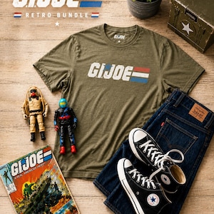 May include: An olive green t-shirt with the text "G.I. Joe" in white, red, and blue, alongside dark wash denim jeans, black Converse trainers, and a vintage comic book. The image also includes two action figures and a military-style box.