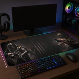 May include: A large rectangular gaming mouse pad featuring a dark, action-themed graphic of soldiers with weapons. The pad is positioned on a wooden desk with a backlit keyboard, mouse, and computer components.